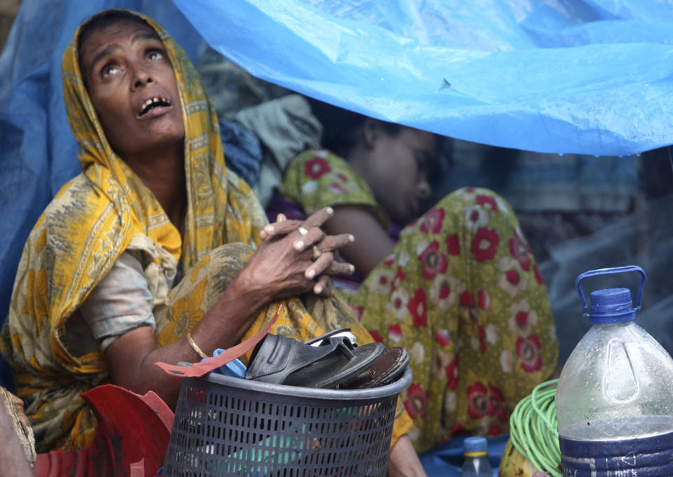 FILE - In this July, 28, 2009 file photo, a Bangladeshi woman looks skyward from inside her temporary home, a tent set up on the roadside, in Dhaka, Bangladesh as heavy monsoon rains have battered Bangladesh's capital, flooding streets and homes, stranding thousands and forcing businesses and schools to close. Experts say Asia and the South Pacific, home to 4.3 billion people or 60 percent of all humankind, faces rising risks from climate change that threaten food security, public health and social order, in a report given Monday, March 31, 2014 by a United Nations scientific panel meant to guide policymakers and form the foundation for a new climate treaty due next year. (AP Photo/Pavel Rahman, File)