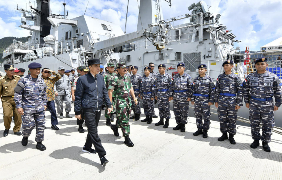 In this photo released Indonesian Presidential Office, Indonesian President Joko Widodo, center, inspect troops during his visit at Indonesian Navy ship KRI Usman Harun at Selat Lampa Port, Natuna Islands, Indonesia, Wednesday, Jan. 8, 2020. Indonesian President Joko Widodo on Wednesday visited the Natuna islands that overlap with China's expansive claim to the South China Sea amid heightened tensions over the waters after Beijing recently claimed it was their traditional fishing area. (Agus Soeparto, Indonesian Presidential Office via AP)