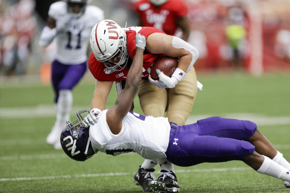 Northwestern defensive back Coco Azema (27) tackles Wisconsin tight end Jake Ferguson (84) during the first half of an NCAA college football game Saturday, Sept. 28, 2019, in Madison, Wis. (AP Photo/Andy Manis)