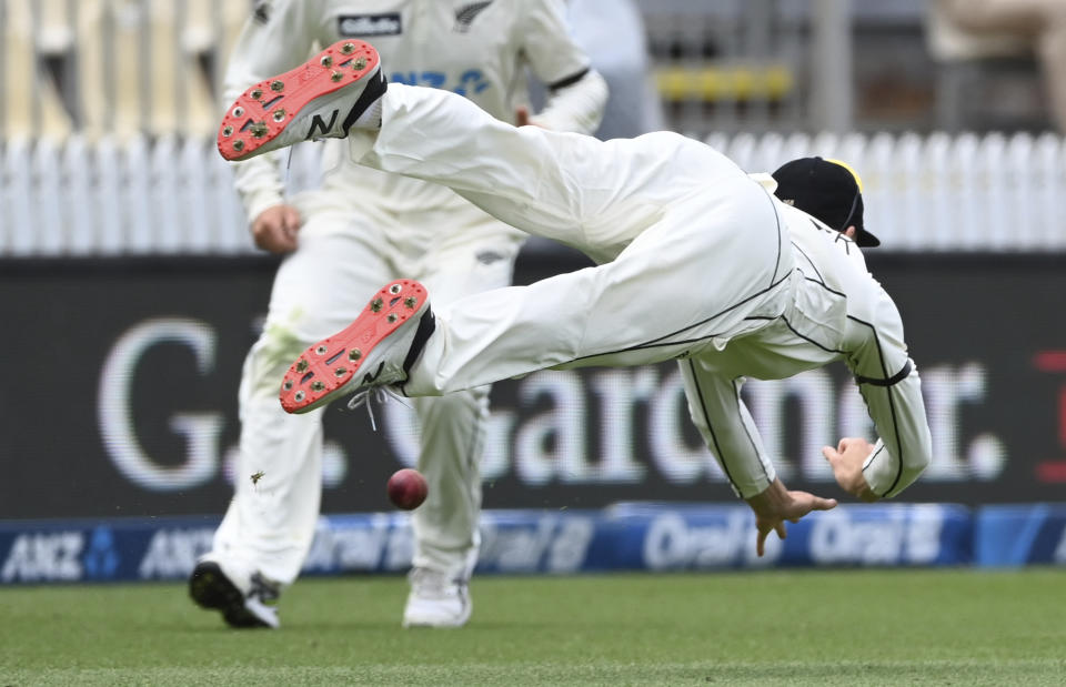 New Zealand's Mitchell Santner is unable to make a diving catch against the West Indies during play on day three of their first cricket test in Hamilton, New Zealand, Saturday, Dec. 5, 2020. (Andrew Cornaga/Photosport via AP)