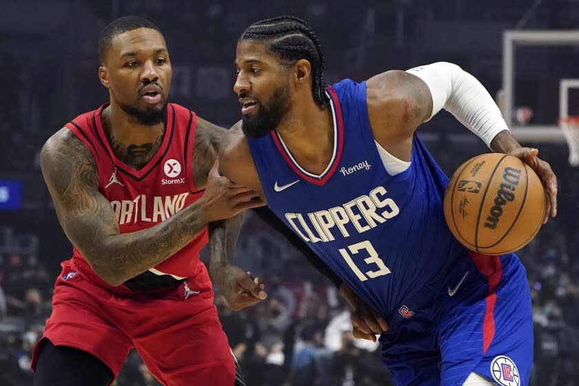 Clippers guard Paul George dribbles past by Blazers guard Damian Lillard