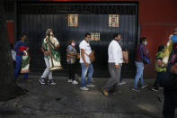 Faithful wearing protective face masks amid the new coronavirus, wait in line to enter the San Hipolito Catholic church as part of the annual pilgrimage honoring Saint Jude, the patron saint of lost causes, in Mexico City, Wednesday, Oct. 28, 2020. Thousands of Mexicans did not miss this year to mark St. Jude's feast day, but the pandemic caused Masses to be canceled and the rivers of people of other years were replaced by orderly lines of masked worshipers waiting their turn for a blessing. (AP Photo/Marco Ugarte)