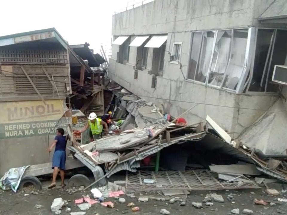 Rescue crew members look for trapped victims at a collapsed building at Padada market in Padada, Philippines, on 15 December 15 2019: Vincent Yaj Makiputin/Reuters