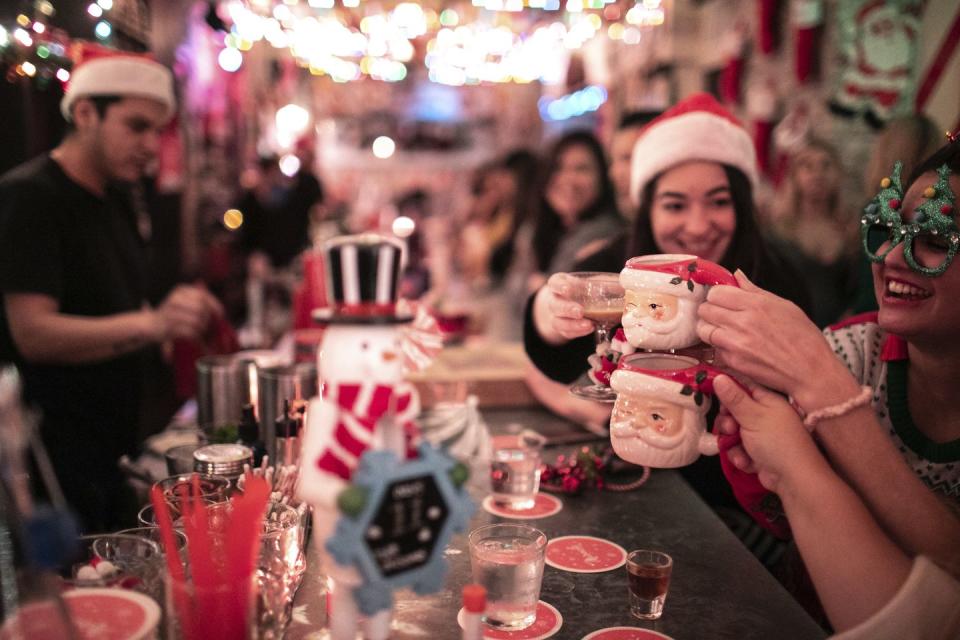 a group of people holding cups with christmas decorations