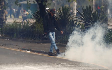 A demonstrator kicks a tear gas canister during protests after Ecuador's President Lenin Moreno's government ended four-decade-old fuel subsidies in Quito