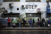 FILE - People line up for a free, hot meal outside a soup kitchen run by the Excluded Workers Movement in Buenos Aires, Argentina, March 13, 2024. Organizers said the kitchen is open three days a week and serves about 4,000 people a day, but because of the increasing number of people coming for meals, they often don't have enough to go around. (AP Photo/Natacha Pisarenko, File)