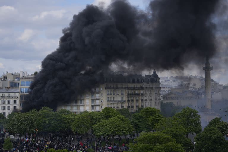 El humo ondea en la Place de la Nation después de que unos jóvenes prendieran fuego durante una manifestación, el lunes 1 de mayo de 2023 en París.