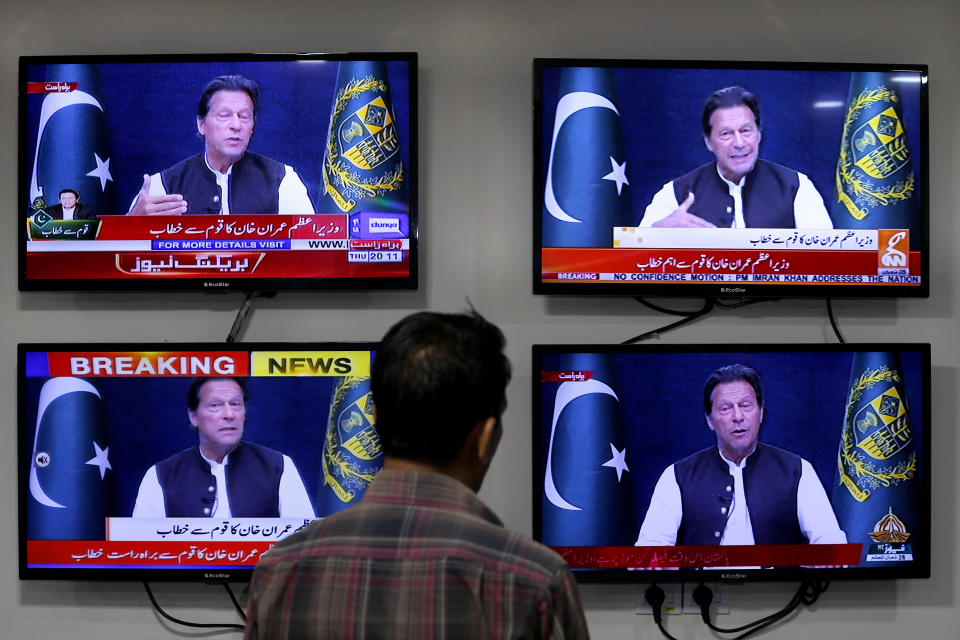 A man watches news channels broadcast a live address to the nation by Pakistan's Prime Minister Imran Khan, in Islamabad, Pakistan, Thursday, March 31, 2022. Pakistan's embattled Prime Minister Khan remained defiant on Thursday, telling the nation that he will not resign even as he faces a no-confidence vote in parliament and the country's opposition says it has the numbers to push him out. (AP Photo/Anjum Naveed)