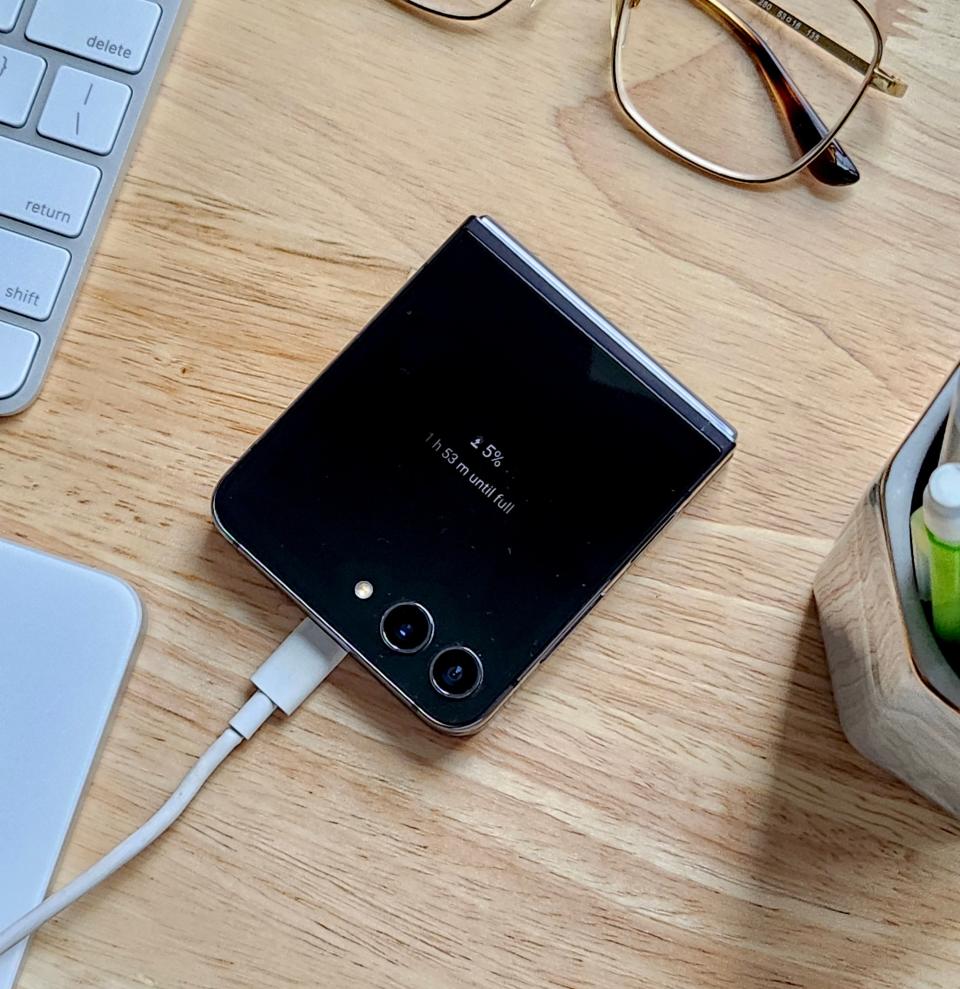 Flip 5 charging with the cover screen displaying the current battery percentage and how much time until the phone is fully charged