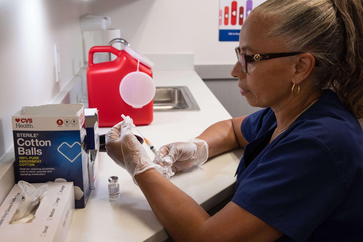 CVS pharmacist prepares syringe for immunization amidst high rates of Influenza, COVID-19 and RSV nationally