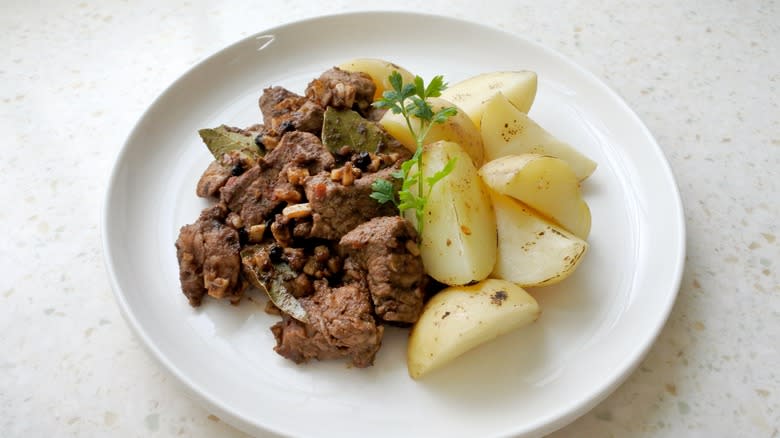 carne de vinha d'alhos potatoes on a white plate