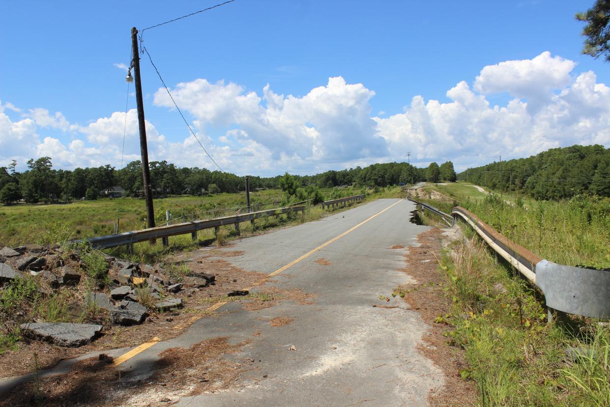 The road atop Sanford Dam in Boiling Spring Lakes remains closed as the city waits for funding to rebuild it.