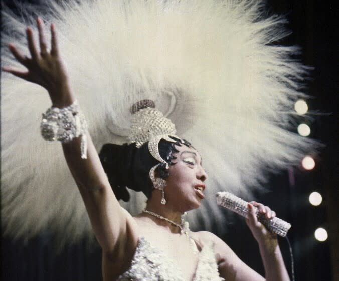 FILE - In this file photo dated May 27, 1957, Entertainer Josephine Baker holds a rhinestone-studded microphone as she performs during her show "Paris, mes Amours" at the Olympia Music Hall in Paris, France. The remains of American-born singer and dancer Josephine Baker will be reinterred at the Pantheon monument in Paris, Le Parisien newspaper reported Sunday Aug. 22, 2021, that French President Emmanuel Macron has decided to bestow the honor. Josephine Baker is a World War II hero in France and will be the first Black woman to get the country's highest honor. (AP Photo/File)