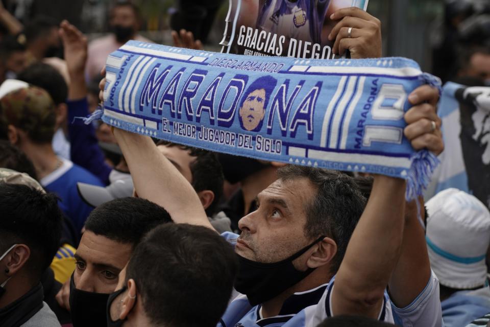A man holds up a Diego Maradona scarf outside the presidential palace in Buenos Aires.