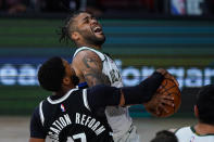 Milwaukee Bucks guard Frank Mason III (15) is fouled as he shoots by Brooklyn Nets guard Garrett Temple (17) during the second half of an NBA basketball game Tuesday, Aug. 4, 2020 in Lake Buena Vista, Fla. (AP Photo/Ashley Landis)