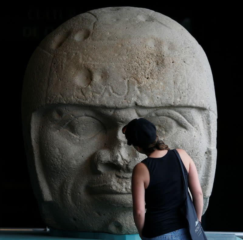 FILE PHOTO: Visitor looks at an Olmec colossal head during the preview of "Colossal masterworks of the Olmec world" exhibition at the Anthropology Museum in Mexico City