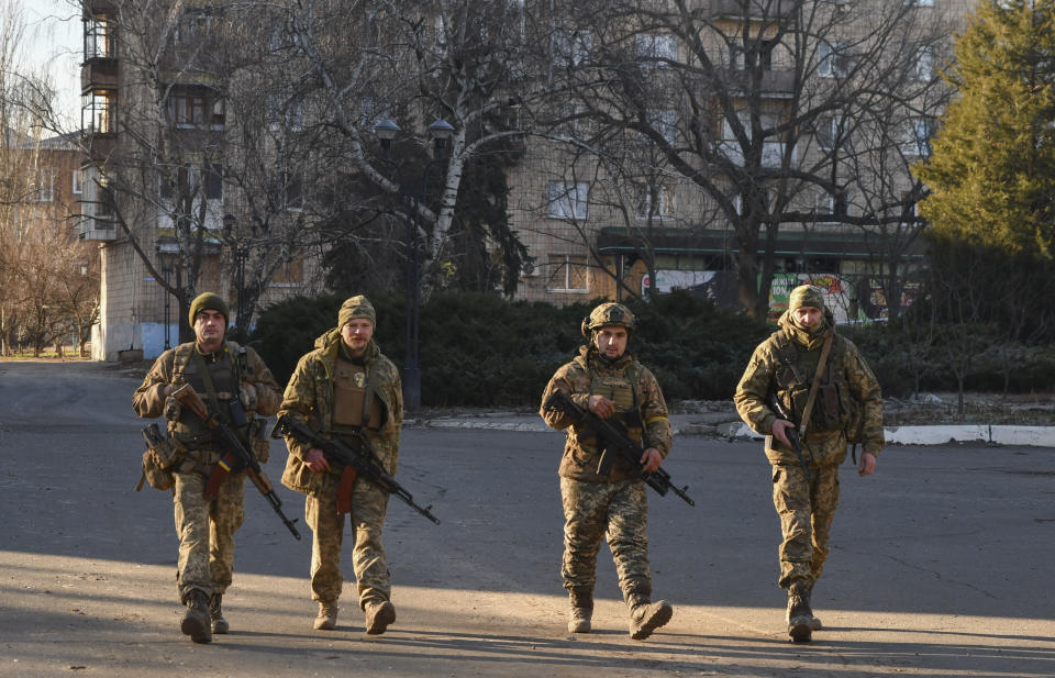 Ukrainian soldiers walk along a street in the area of the heaviest battles with the Russian invaders in Bakhmut, Ukraine, Tuesday, Dec. 20, 2022. (AP Photo/Andriy Andriyenko)