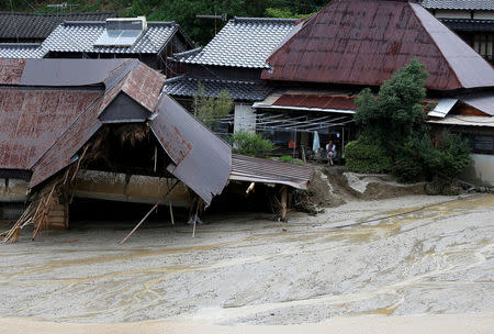 A local resident is seen at his home next to mudcaused by heavy rain in Asakura, Fukuoka Prefecture, Japan July 8, 2017. REUTERS/Issei Kato