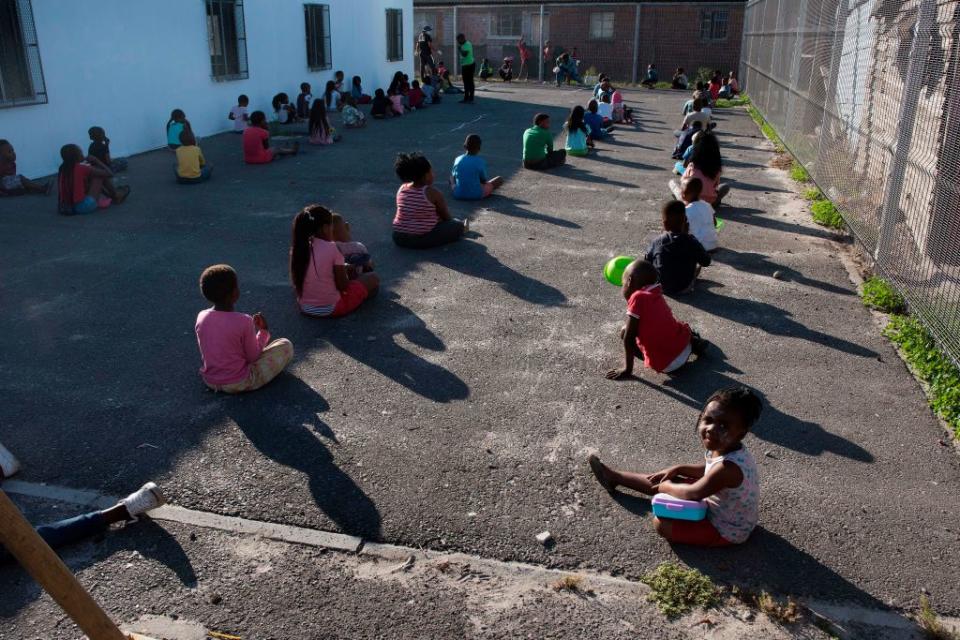 Children social distancing at a nursery near Cape Town wait with bowls to receive soup handed out by the government to prevent the poor from starving amid the pandemic. Source: Getty