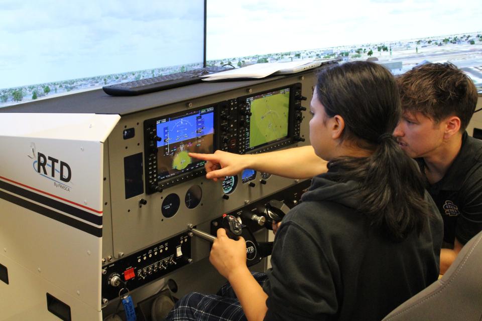 Idialish Fuentes De Jesus (left) gets ready for "liftoff" on the aviation simulators as certified flight instructor Parker Reyes (right) from South Dakota State University points to one of the controls at the Career and Technical Education Academy on Wednesday, Sept. 27, 2023.