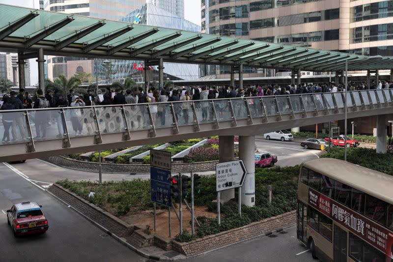 Anti-government office workers attend a lunch time protest on a pedestrian bridge in Hong Kong