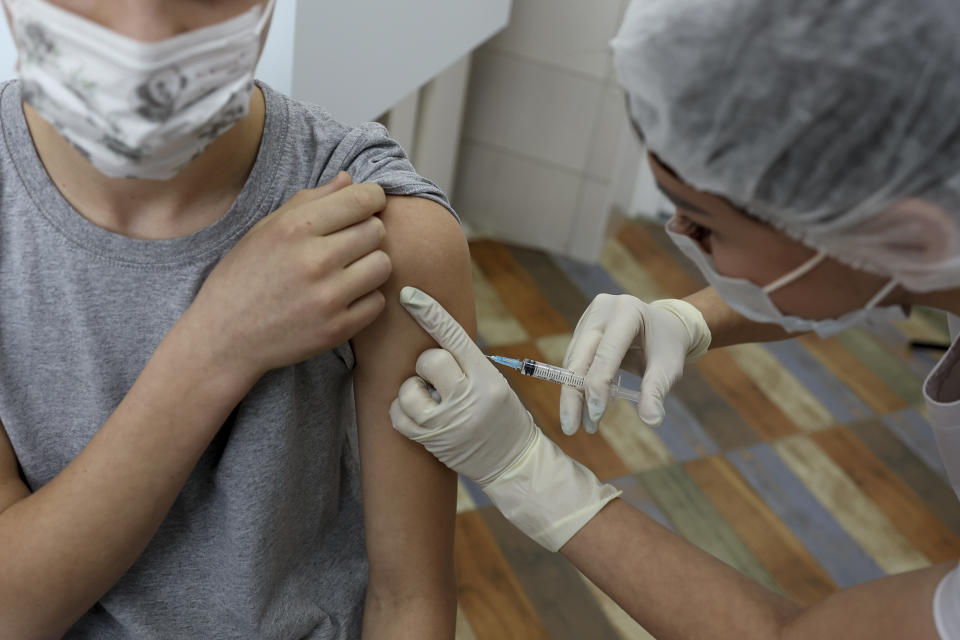 A teenager receives a dose of Russia's Sputnik M (Gam-COVID-Vac-M) COVID-19 vaccine in Krasnodar, Russia, Friday, Jan. 28, 2022. This week, Russia started vaccinating children aged 12-17 with a domestically developed shot, Spuntik M — a version of the Sputnik V vaccine that contains a smaller dose — amid reports of a sharp spike of COVID-19 infections and hospitalization in children. (AP Photo/Vitaliy Timkiv)