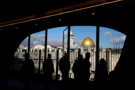 FILE PHOTO: People look out from a building facing the Dome of the Rock (R), located in Jerusalem's Old City on the compound known to Muslims as Noble Sanctuary and to Jews as Temple Mount December 7, 2017. REUTERS/Ronen Zvulun/File Photo