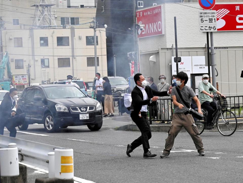 A police officer detains a man, believed to have shot former Japanese prime minister Shinzo Abe, in Nara, western Japan on 8 July 2022 (Reuters)