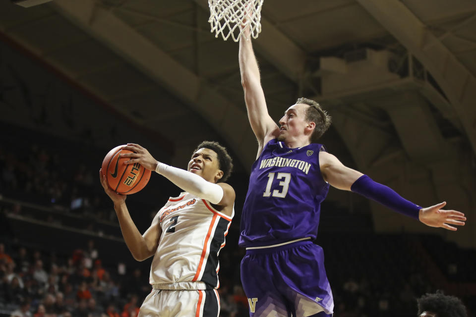 Oregon State guard Josiah Lake II (2) drives to the basket as Washington forward Moses Wood (13) defends during the first half of an NCAA college basketball game Saturday, Feb. 10, 2024, in Corvallis, Ore. (AP Photo/Amanda Loman)