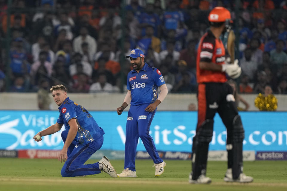 Mumbai Indians' Cameron Green, left, fields a ball during the Indian Premier League cricket match between Sunrisers Hyderabad and Mumbai Indians in Hyderabad, India, Tuesday, April 18, 2023. (AP Photo/Mahesh Kumar A.)