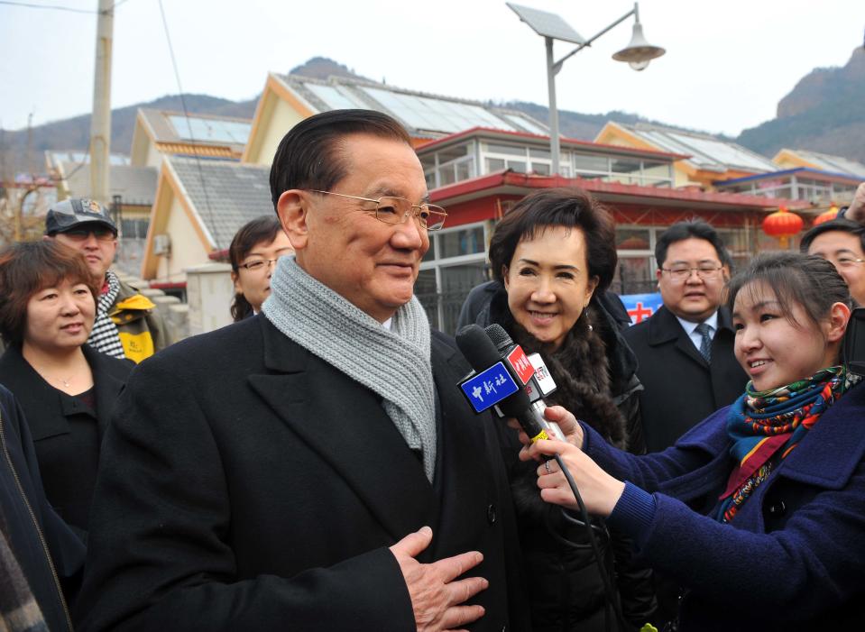 In this photo provided by China's Xinhua News Agency, Taiwan's Kuomintang Honorary Chairman Lien Chan, center, speaks to the media after visiting the village of Guajiayu on the outskirts of Beijing, China, Tuesday, Feb. 18, 2014. Lien, also chairman of a foundation on cross-Strait peaceful development, is leading a delegation from Taiwan for a four-day visit to the Chinese mainland. (AP Photo/Xinhua, Chen Yehua) NO SALES