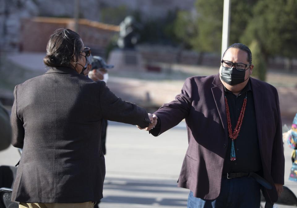 Navajo Nation council delegate Nathaniel Brown bumps fists with Speaker of Council Seth Damon during a visit with first lady Jill Biden at Window Rock Navajo Tribal Park & Veterans Memorial on April 22, 2021.