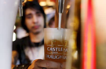 A barman pours a beer produced by brewing company SAB Miller at a bar in Cape Town, in this September 16, 2015 file photo. REUTERS/Mike Hutchings/Files