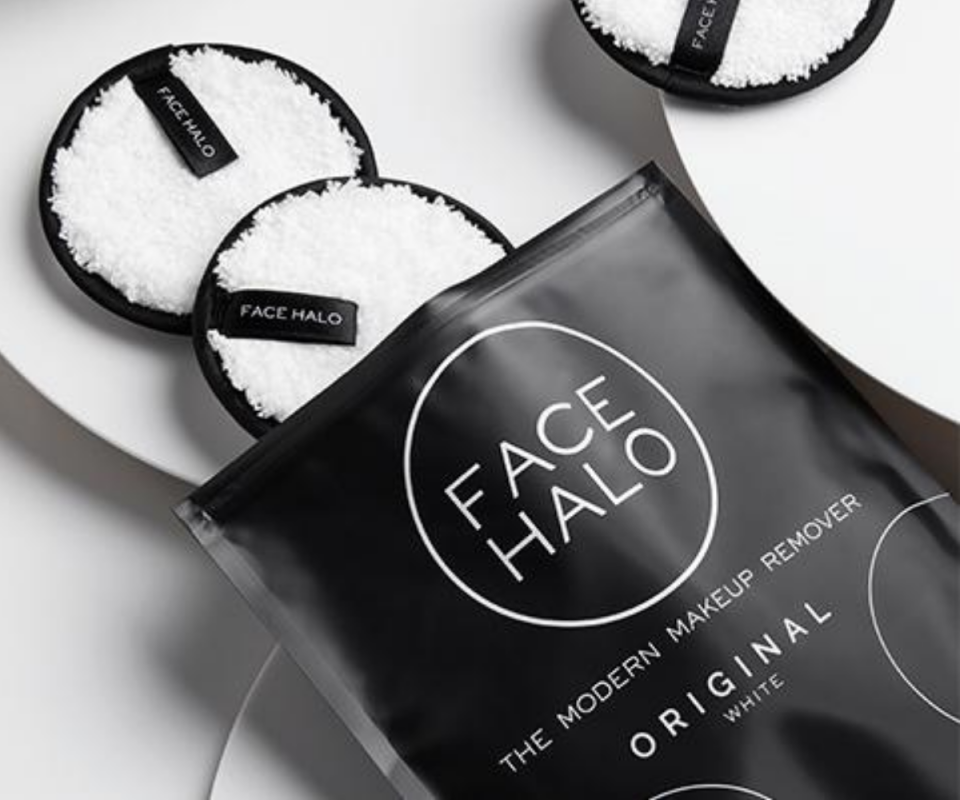 The black pouch package with Face Halo's three white makeup remover pads spilling out of it.