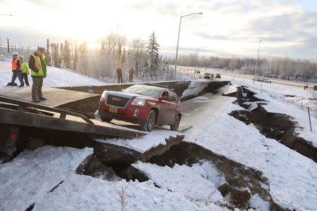 A stranded vehicle is pulled out of a collapsed section of roadway near the airport after an earthquake in Anchorage, Alaska, U.S. November 30, 2018. REUTERS/Nathaniel Wilder