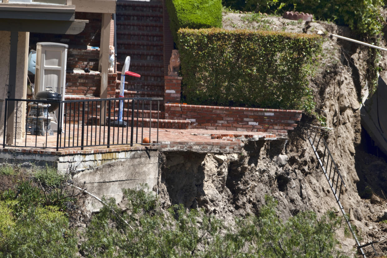 A patio of a house in Rolling Hills Estates is severely damaged after a landslide on the Palos Verdes Peninsula in Los Angeles County, on Monday, July 10, 2023. The Los Angeles County city of Rolling Hills Estates were hastily evacuated by firefighters Saturday when cracks began appearing in structures and the ground. (AP Photo/Richard Vogel)