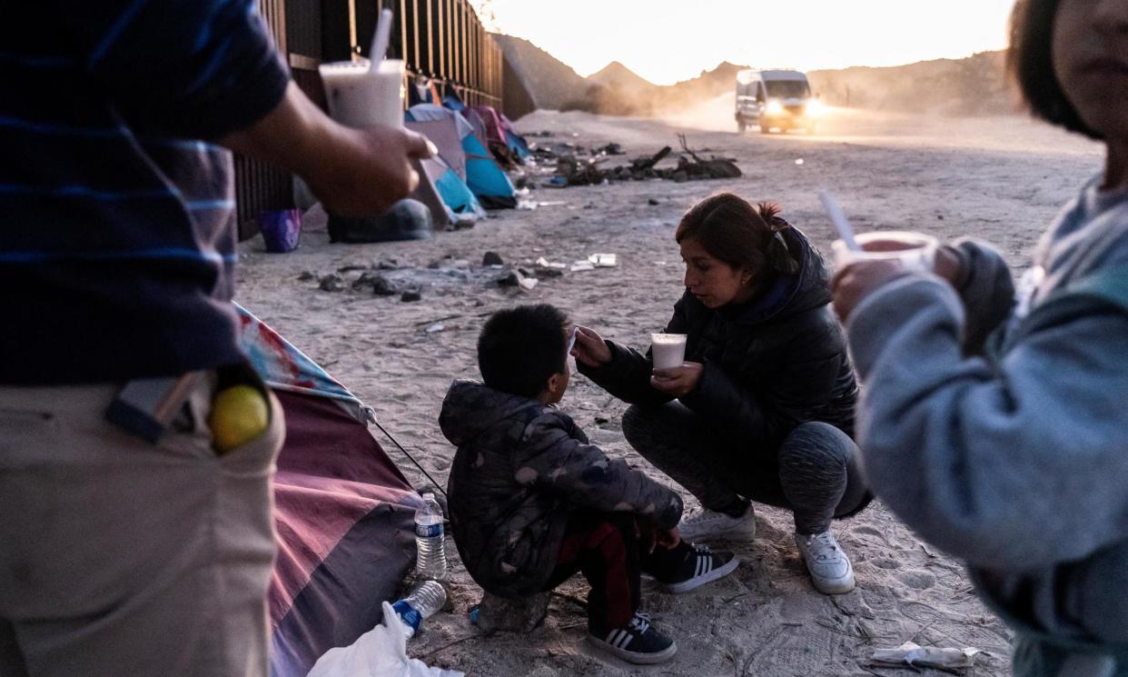 <span>A mother from Peru feeds her son at the California-Mexico border in Jacumba Hot Springs, California, on 11 November November 2023.</span><span>Photograph: Go Nakamura/Reuters</span>