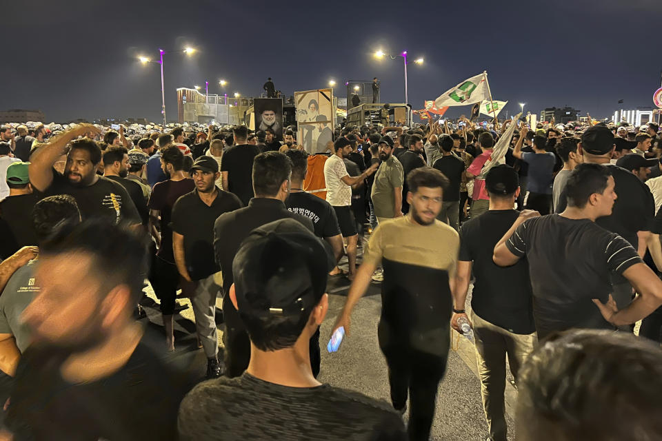 Protesters gather in Baghdad's Tahrir Square, carrying Iraqi flags and images of influential Iraqi Shiite cleric and political leader Muqtada al-Sadr, Saturday, July 22, 2023, following reports of the burning of a Quran carried out by a ultranationalist group in front of the Iraqi Embassy in Copenhagen. Protesters attempted to cross the Jumhuriya bridge leading to the Green Zone, where the Danish embassy is, but were pushed back by security forces. (AP Photo/Ali Jabar)