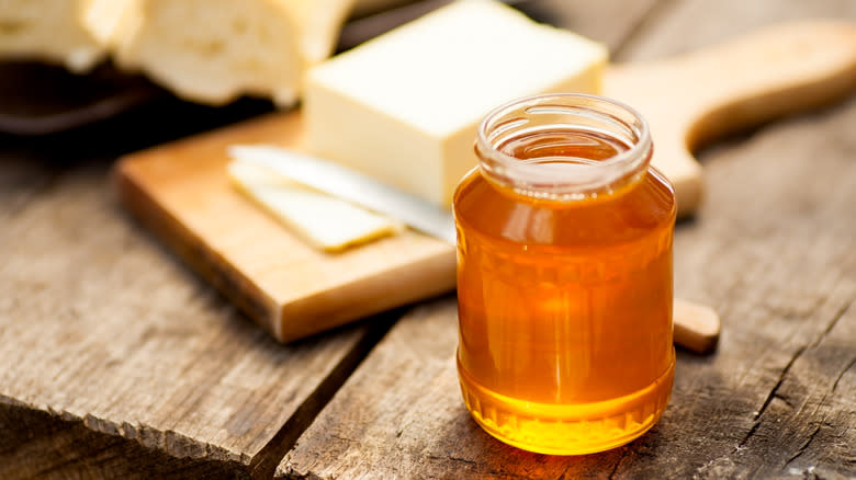 Honey in jar beside butter