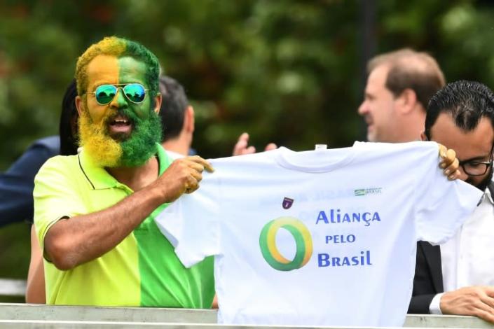 A supporter of Brazilian President Jair Bolsonaro holds a t-shirt during the launch of Bolsonaro's new party, the Alliance for Brazil, at a hotel in Brasilia (AFP Photo/EVARISTO SA)