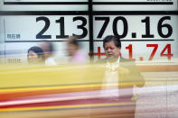 People stand near an electronic stock board showing Japan's Nikkei 225 index at a securities firm in Tokyo Tuesday, Sept. 10, 2019. Asian shares were mixed Tuesday after a day of listless trading on Wall Street, as investors awaited signs on global interest rates.(AP Photo/Eugene Hoshiko)