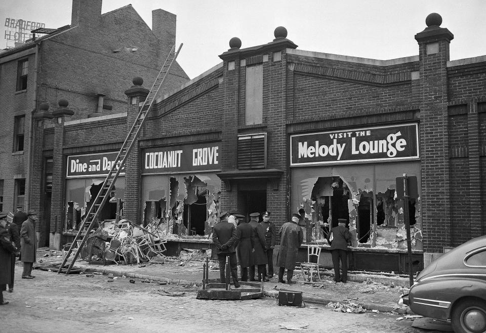 FILE - In this Nov. 29, 1942 file photo, police and firemen stand at the rear entrance to the "Melody Lounge" section of the Cocoanut Grove nightclub in Boston the morning after a fire that killed 492 people. A 2019 documentary film, "Six Locked Doors: The Legacy of Cocoanut Grove," tells the story of the disaster that led to an overhaul and stricter enforcement of building safety codes. (AP Photo, File)
