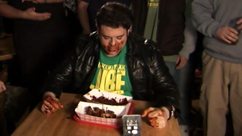 Adam Richman struggles against the hellfire wings