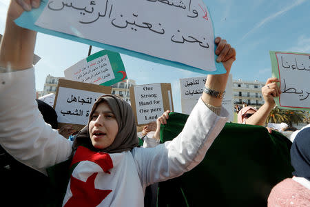 Demonstrators carry signs as teachers and students take part in a protest demanding immediate political change in Algiers, Algeria March 13, 2019. REUTERS/Zohra Bensemra