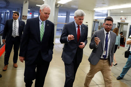 Sen. Bill Cassidy (R-LA), accompanied by Sen. Ron Johnson (R-WI) at left, speaks with reporters ahead of the party luncheons on Capitol Hill in Washington, U.S., September 26, 2017. REUTERS/Aaron P. Bernstein