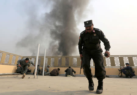 Afghan police officers take position during a blast and gun fire in Jalalabad, Afghanistan January 24, 2018.REUTERS/Parwiz TPX IMAGES OF THE DAY