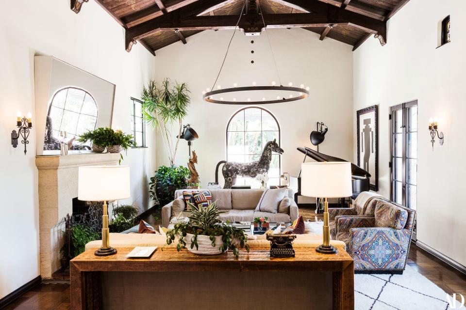 The living room is one of the only spaces left white, whereas the couple’s previous home was almost entirely so. The gold-accented vaulted ceiling is a highlight, while the iron horse from Timothy Oulton stands out as a focal point. Mikita’s first and ultimately most important selection for the house—the very first thing they bought for it—informed the rest of the design, which melds humor with sophistication. There are Restoration Hardware sofas, tables they had built from reclaimed warehouse wood, a mirror made in the Warner Bros. metal shop, and spotlights from a shuttered restaurant in Los Angeles.