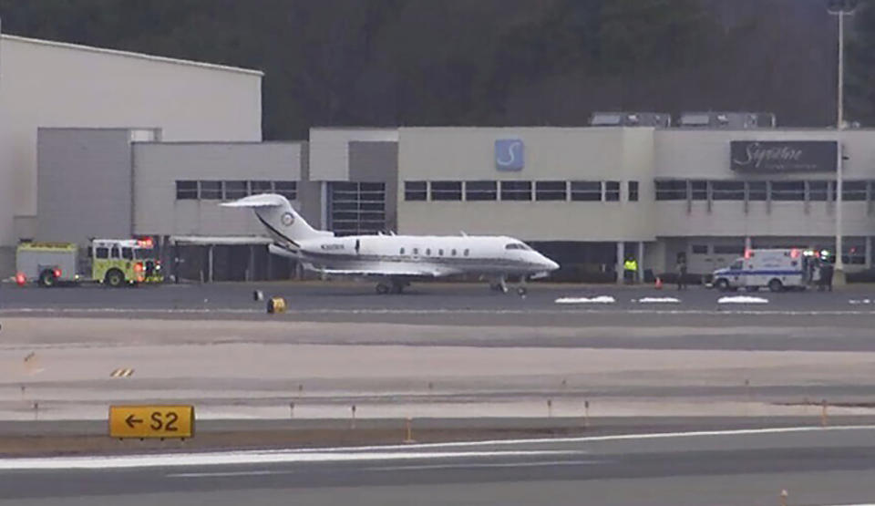 FILE - Emergency vehicles flank a Bombardier Challenger 300 that diverted to Bradley International Airport in Windsor Locks, Conn., Friday, March 3, 2023. Investigators said Friday, March 24, 2023, that a passenger on a business jet was fatally injured in early March when the aircraft violently bucked up and down after pilots disconnected a system used to stabilize the plane. (NBC Connecticut via AP)