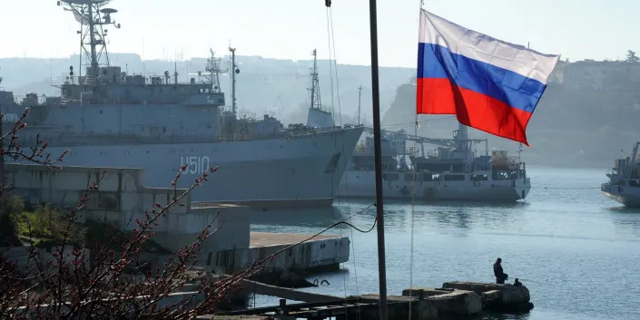 Russian flag in front of boats at port