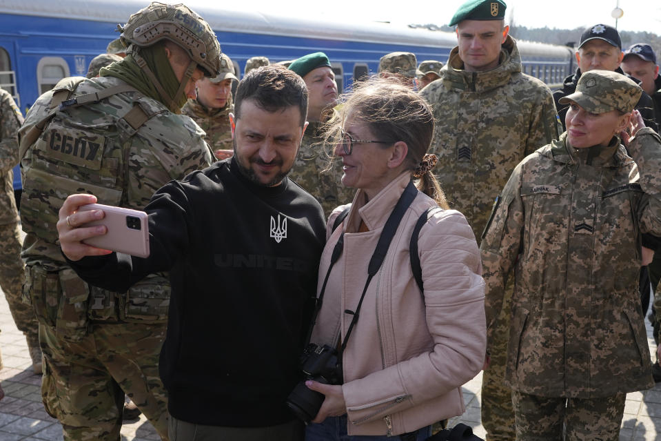 Ukrainian President Volodymyr Zelenskyy takes a selfie during a visit to the train station in Trostianets in the Sumy region of Ukraine, Tuesday March 28, 2023. (AP Photo/Efrem Lukatsky)